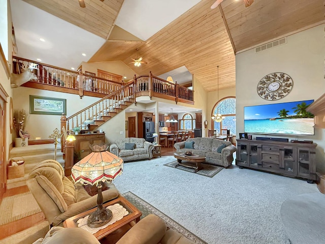 carpeted living area featuring a chandelier, visible vents, stairway, high vaulted ceiling, and wooden ceiling