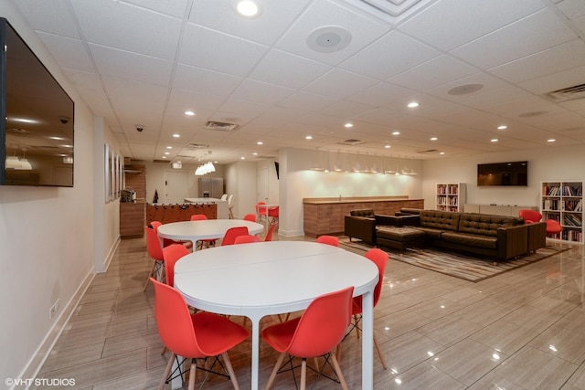 dining space featuring a community bar, baseboards, visible vents, and recessed lighting