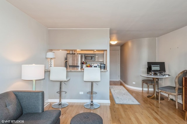 interior space with baseboards and light wood-style floors