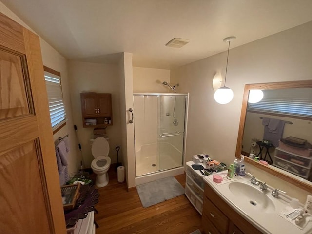 full bathroom featuring toilet, wood finished floors, a shower stall, and vanity