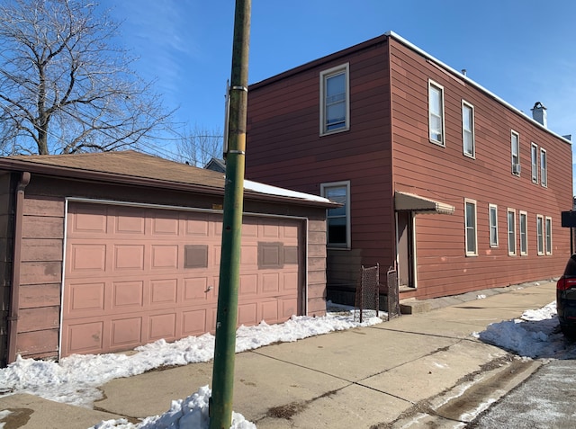 view of snow covered exterior featuring a garage