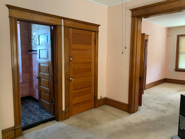 interior space featuring carpet floors, ornamental molding, and baseboards