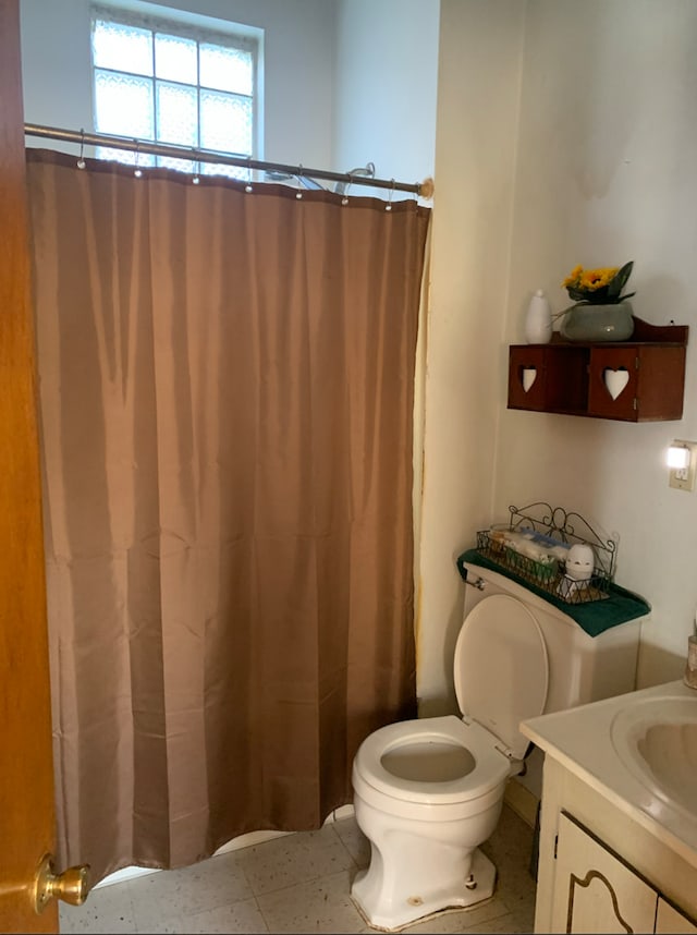 bathroom featuring a shower with curtain, vanity, and toilet