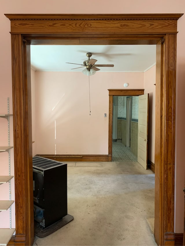 empty room with ceiling fan, unfinished concrete floors, and ornamental molding