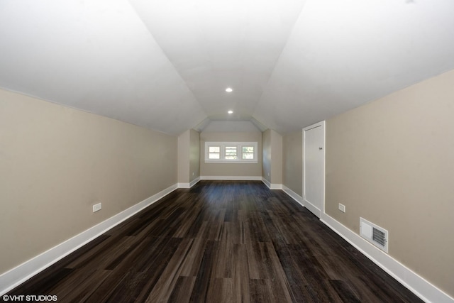 bonus room featuring dark wood-style floors, recessed lighting, visible vents, vaulted ceiling, and baseboards