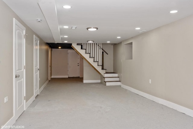 finished below grade area featuring stairs, baseboards, and recessed lighting