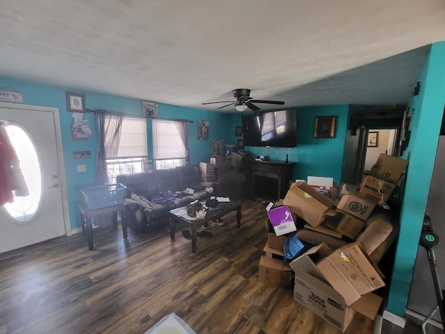 living area featuring ceiling fan and dark wood-style flooring