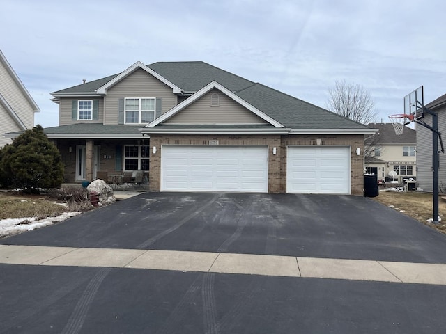 view of front of property with a shingled roof, brick siding, driveway, and an attached garage