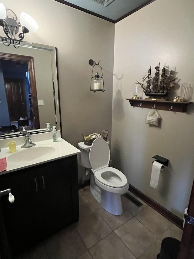 bathroom featuring tile patterned flooring, toilet, vanity, baseboards, and ornamental molding