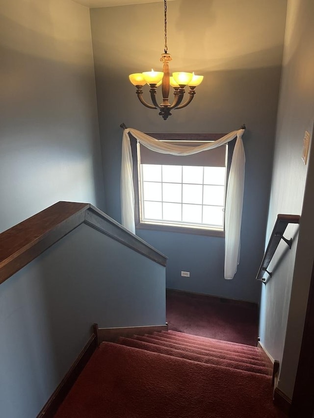 stairway featuring carpet floors and a notable chandelier