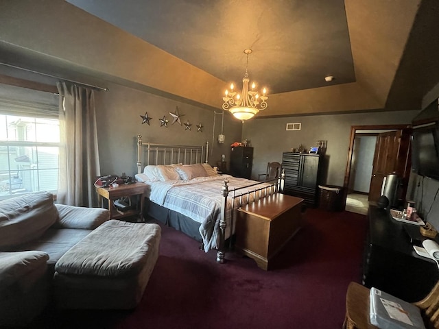 carpeted bedroom with visible vents, a tray ceiling, and a notable chandelier