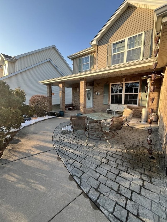 view of front facade featuring a patio and brick siding