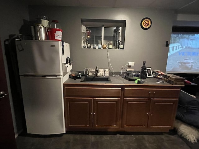 bar featuring a sink and freestanding refrigerator