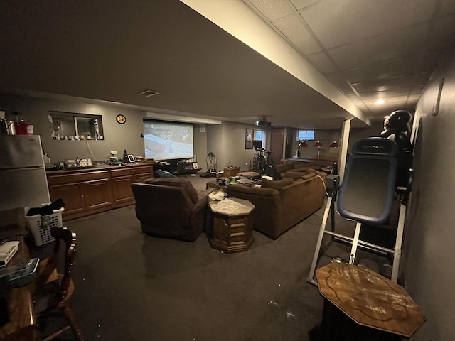 interior space with visible vents, dark colored carpet, and a drop ceiling