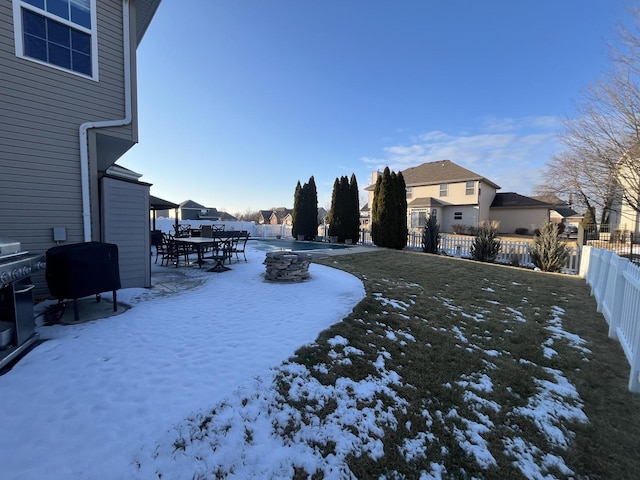 yard covered in snow featuring a fenced backyard and a residential view