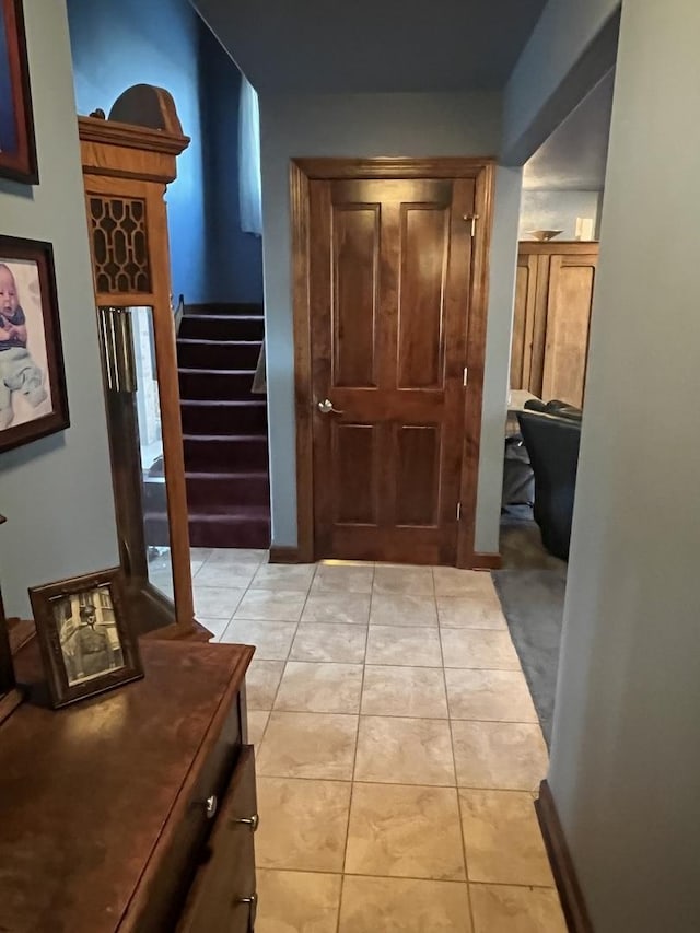 corridor featuring stairs and light tile patterned flooring