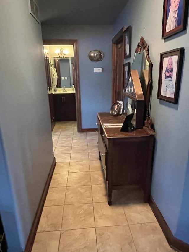 corridor with light tile patterned flooring and baseboards