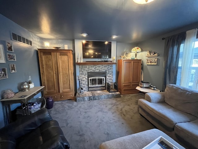 living area featuring a tiled fireplace, visible vents, and carpet flooring