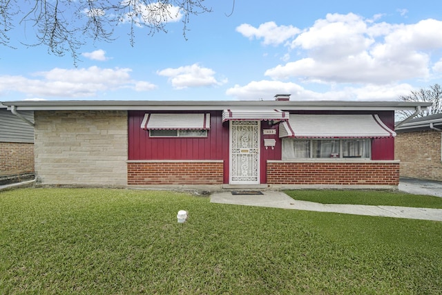 view of front of house with a front yard and brick siding