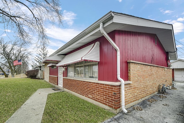 view of property exterior with a garage, a yard, and brick siding