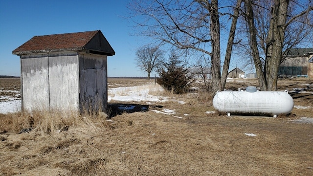 snowy yard with an outdoor structure and a storage shed