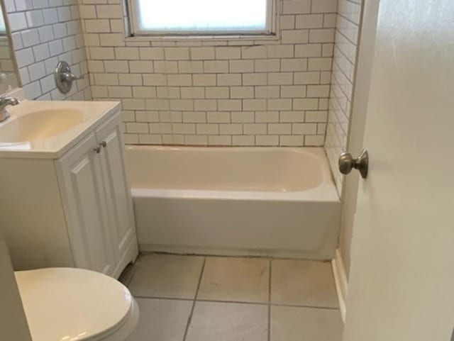 bathroom featuring  shower combination, vanity, toilet, and tile patterned floors