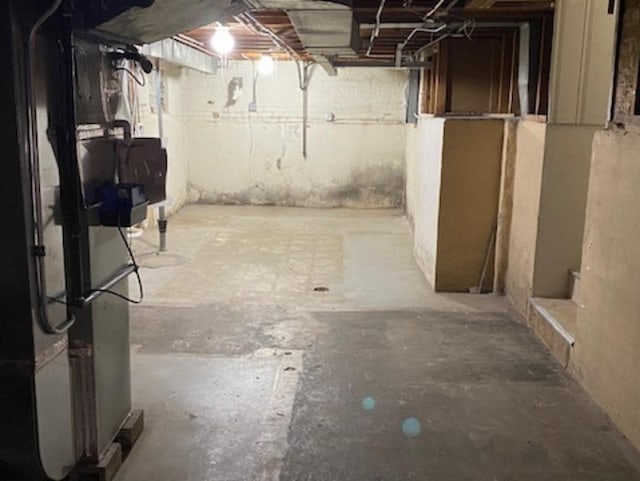 unfinished basement featuring heating unit