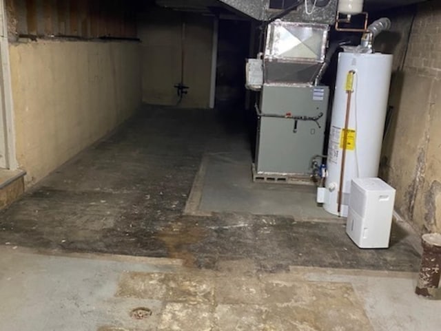 unfinished basement featuring gas water heater and heating unit