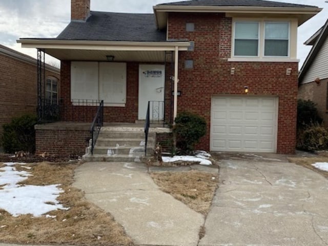 split level home featuring concrete driveway, brick siding, a chimney, and an attached garage