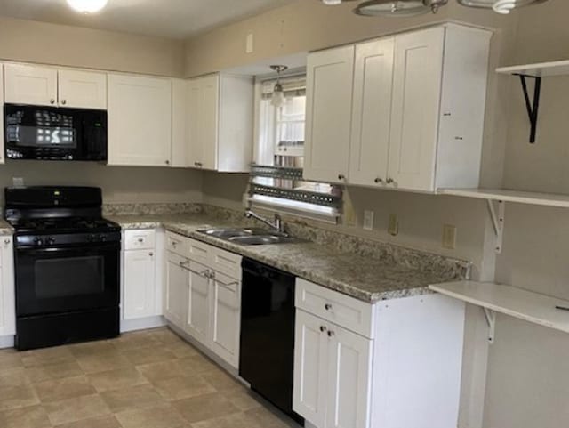 kitchen featuring black appliances, light stone counters, a sink, and white cabinetry