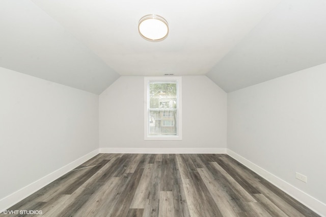 bonus room with lofted ceiling, baseboards, and dark wood-type flooring