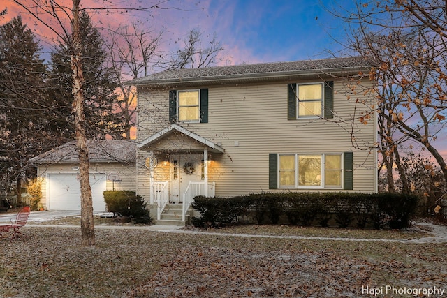 traditional home featuring an attached garage and driveway