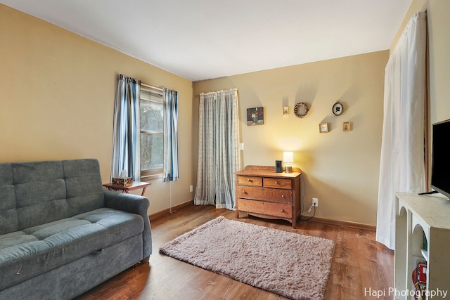 sitting room featuring dark wood-type flooring and baseboards