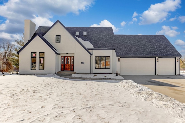 modern farmhouse style home featuring an attached garage, concrete driveway, and roof with shingles