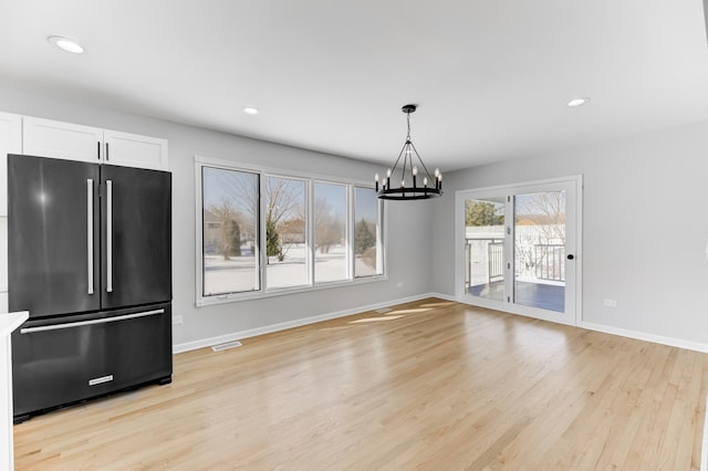 unfurnished dining area with light wood-type flooring, visible vents, baseboards, and recessed lighting