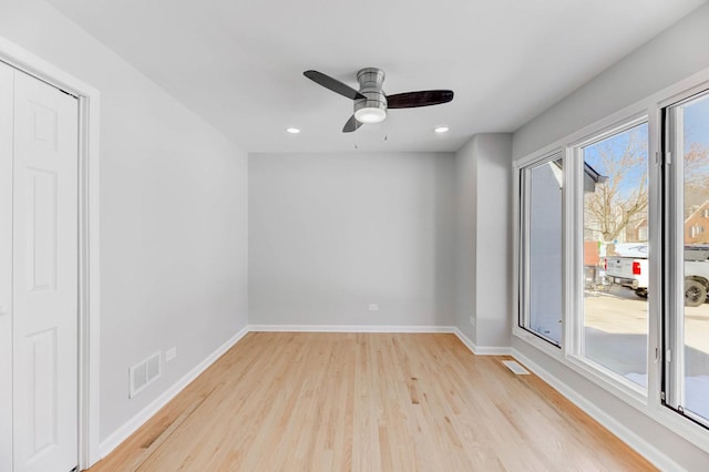 spare room with visible vents, light wood-style flooring, and baseboards