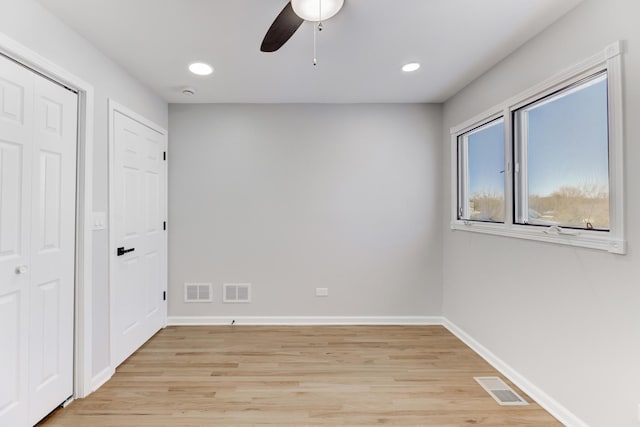 empty room featuring recessed lighting, visible vents, light wood-style flooring, and baseboards