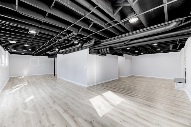 finished below grade area featuring light wood-style flooring and baseboards