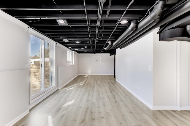 basement with light wood-style flooring and baseboards