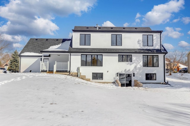 view of snow covered back of property