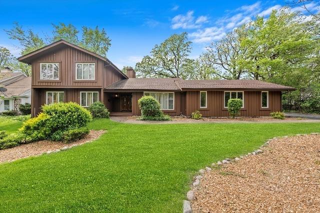 view of front of property featuring a chimney, a front yard, and board and batten siding