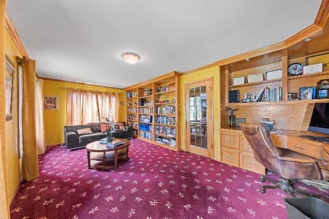 home office with ornamental molding, carpet flooring, and built in desk