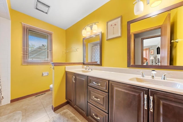 bathroom with toilet, visible vents, and a sink