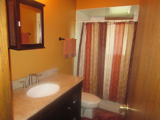 full bathroom featuring a shower with shower curtain, vanity, and toilet