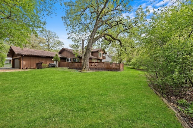 view of yard featuring a garage and a wooden deck