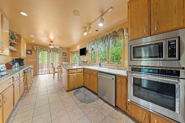 kitchen with light tile patterned floors, stainless steel appliances, recessed lighting, a sink, and a peninsula