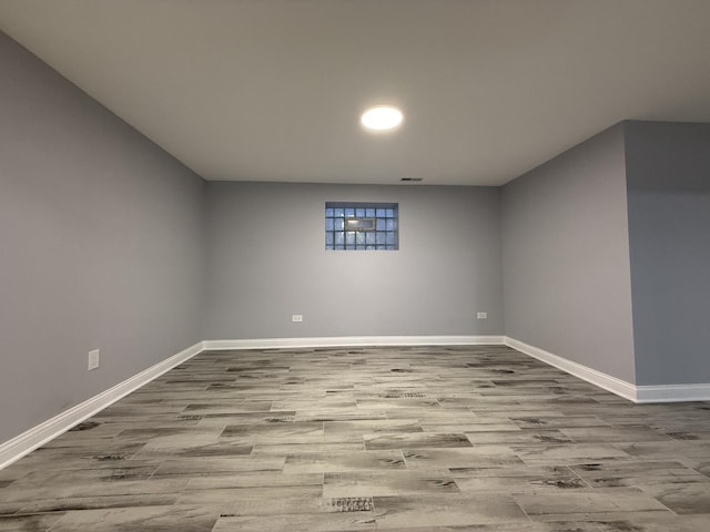 basement featuring light wood finished floors and baseboards