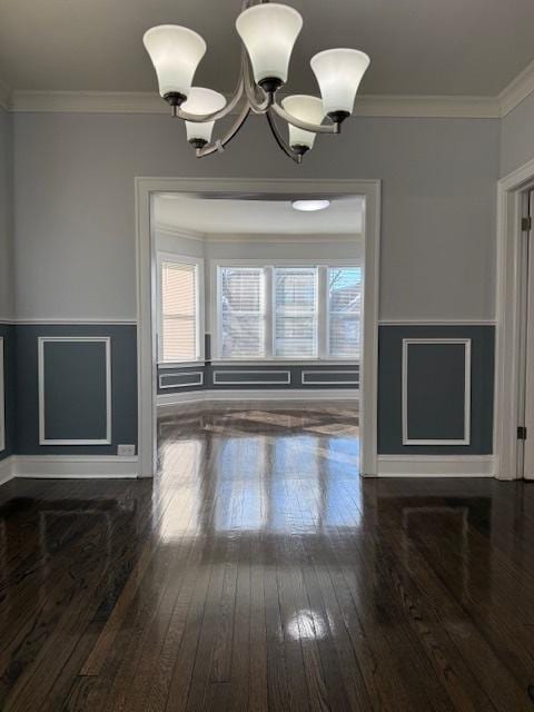 unfurnished dining area featuring a chandelier, dark wood finished floors, and ornamental molding