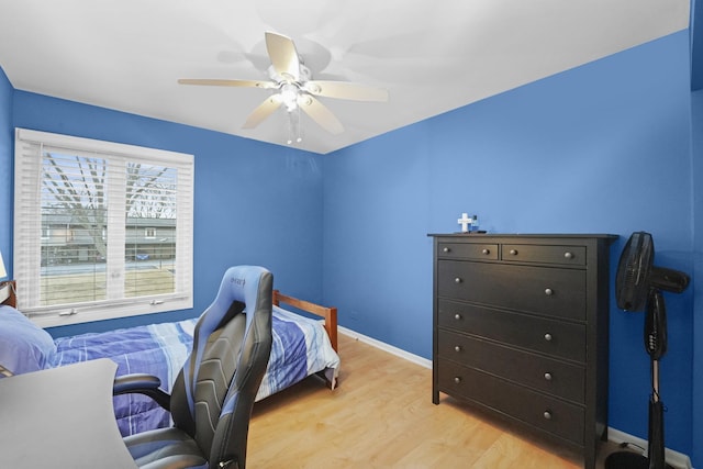 bedroom with a ceiling fan, light wood-style flooring, and baseboards