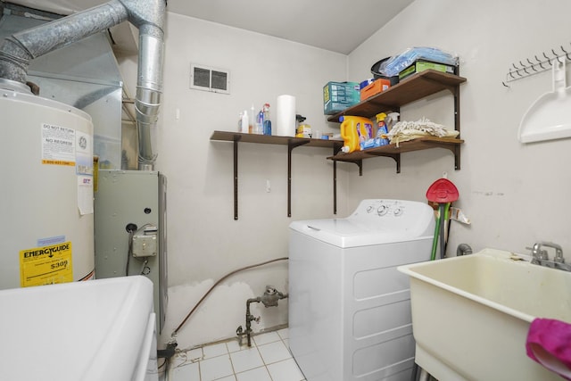 laundry area with visible vents, water heater, a sink, separate washer and dryer, and laundry area